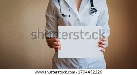 Doctor holding blank white banner. Free space, message, call.