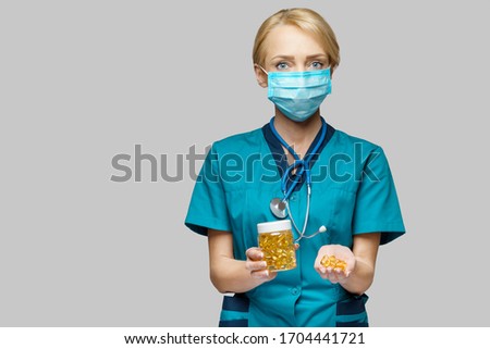 medical doctor nurse woman wearing protective mask and rubber or latex gloves - holding can of pills