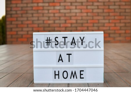 Stay at home' words on lightbox, standing at the door entrance, Safety concept.