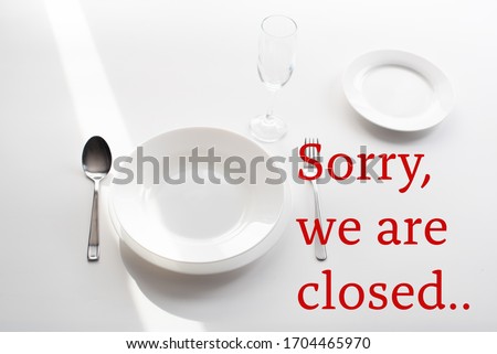 cutlery on the table, serving by the window in a restaurant. Caption Sorry, we are closed, as a concept for closing public places and restaurants during a pandemic.