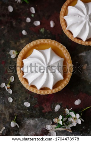 lemon cheesecake pie on wooden background with flower petals.