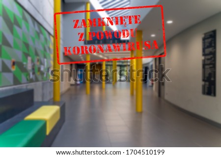 Defocused view of interior entrance of school or college, empty and closed due to covid 19 pandemics with Polish notice Closed due to Coronavirus