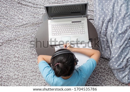 Vietnamese girl studying and learning online with with a laptop in a desk at home due to coronavirus