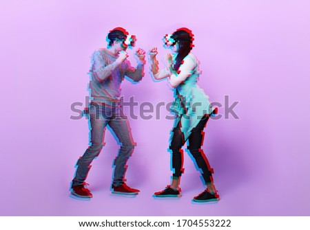 Couple with virtual reality headset are playing game and fighting. Concept of virtual reality, games, entertainment and communication. Image with glitch effect.