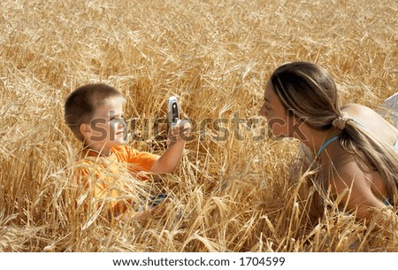 lovely kid picturing mom with cell phone