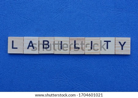 the word lability from gray small wooden letters with black font lies on a dark blue table