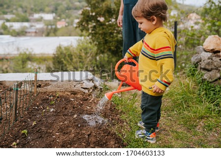 Young boy gardening with his grandfather