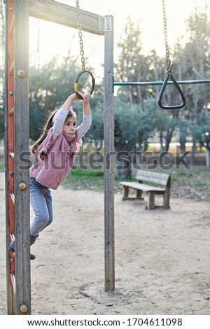 Vertical picture showing a girl playing in the playground in autumn time