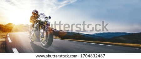 Fast Motorcycle on the coast road riding. having fun driving the empty highway on a motorbike tour journey. copyspace for your individual text. Royalty-Free Stock Photo #1704632467