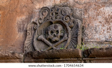 Ornament with a skull and crossbones above the chamber of ancient religious inquisition at cusco cathedral in peru. Royalty-Free Stock Photo #1704654634