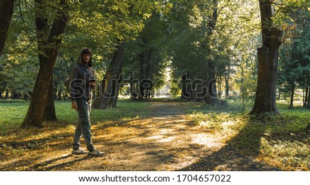 soft focus noise pollution autumn park road concept picture guy portrait looking at camera in morning time with sun rays of light through trees foliage, loneliness promenade theme 