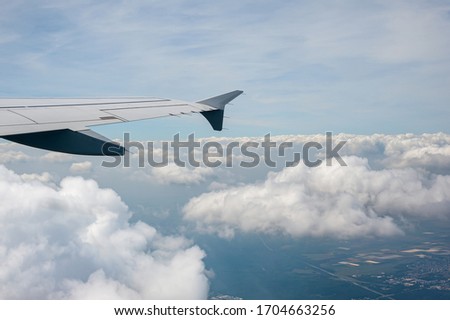 View from airborne airplane window at cloudy sky at high altitude.