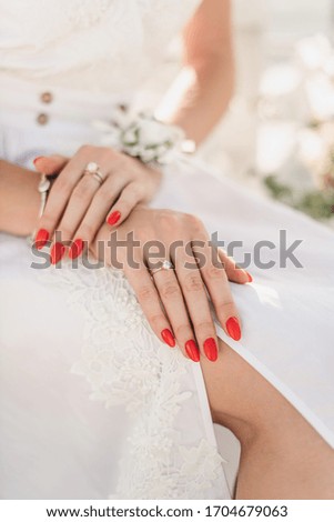 Hands of young girl with wedding cat with diamond in white dress in summer.