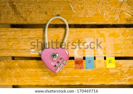 Pink master key and love alphabet on wood pattern background