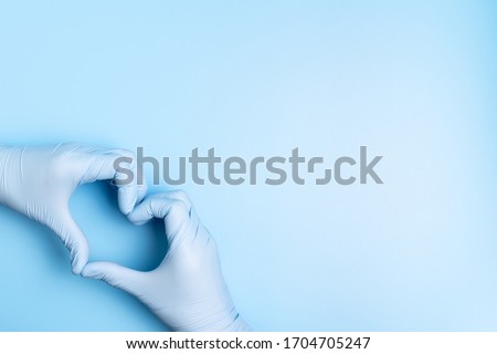 Doctor hands with gloves making heart shape on blue background