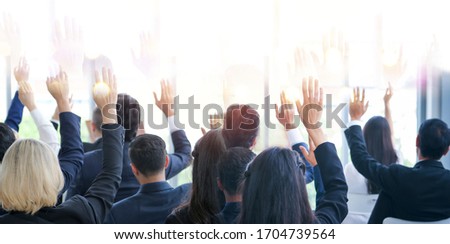 Banner image of back side of business people or employees sitting in conference room or seminar hall while show hand up agree or suggestion