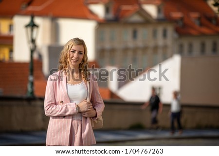 Young blonde woman exploring old town of Prague in sunny day in Czech republic