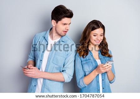 Photo pretty funny lady handsome suspicious guy boyfriend look her telephone read other guy sms cheating lover wear casual denim shirts outfit isolated grey color background