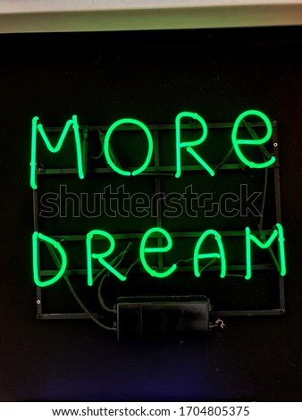 Neon sign phrase 'more dream'.
A glowing neon sign that is often used in shop interior design.