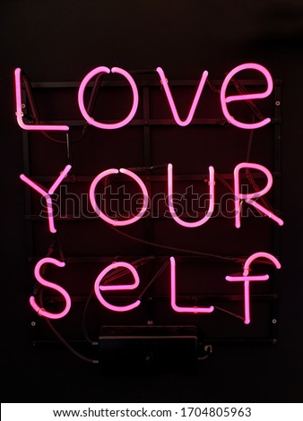 Neon sign phrase 'Love your self'.
A glowing neon sign that is often used in shop interior design.