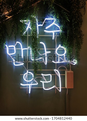 Korean language neon sign. It means 'Let's meet often.'
A glowing neon sign that is often used in shop interior design.