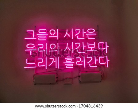 Korean language neon sign. It means 'Their time runs slower than ours.'
A glowing neon sign that is often used in shop interior design.