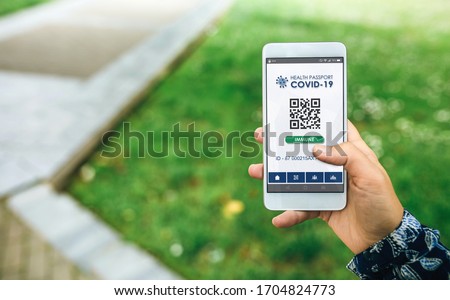 Mobile phone with immune digital health passport for covid-19 held by an unrecognizable woman Royalty-Free Stock Photo #1704824773
