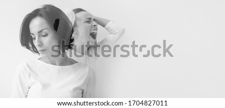 Split identities. Close-up photo of a melancholic woman with multiple personality disorder, who is suffering from negative emotions and mood swings. Double exposure. Royalty-Free Stock Photo #1704827011