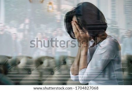 Panic attack. Close-up photo of a woman who is hiding her face with her hands and crying because of her social anxiety. Double exposure photo. Royalty-Free Stock Photo #1704827068