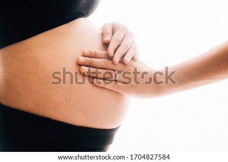 A Young beautiful Asian woman standing in bedroom. mom is love to holding her big belly with two hands. isolated and white background  picture with film grain effect