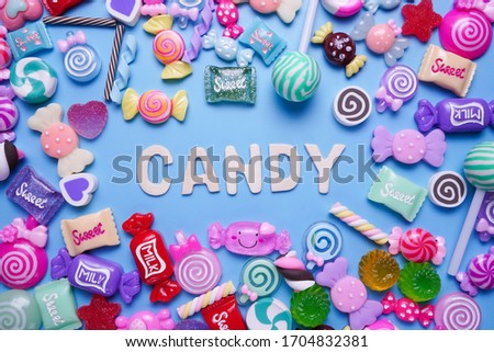 Many candies are arranged in a picture frame with the word "candy" on the blue background.
