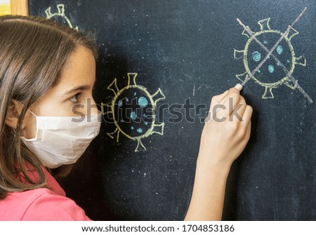 Sad girl crossing out the drawing of a coronavirus on a blackboard