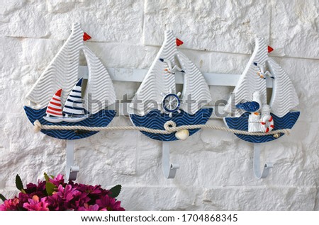 Decoration of sailing boat hanging on the wall with bunch of flowers