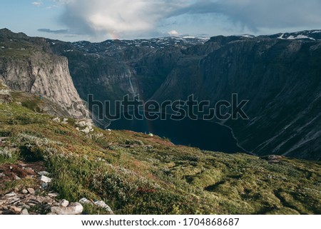 lake Vetlavatnet, Tyssedal
Norwegian fjords with rainbow with mountainous rocky terrain, clouds, grass in summer at sunset. Blue river, beautiful landscape. Traveling in Europe, hiking.