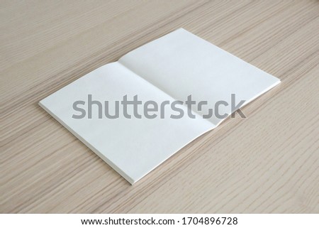 Mock up blank open paper book on wood table background