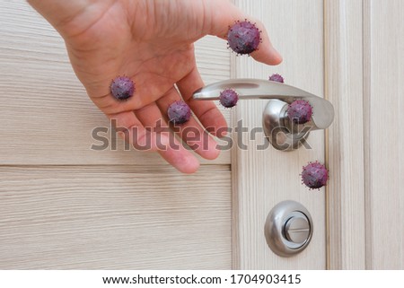 things and objects in everyday life and human life through which germs and viruses spread, door handle in an apartment in a room or house with hand and finger with coronavirus Royalty-Free Stock Photo #1704903415