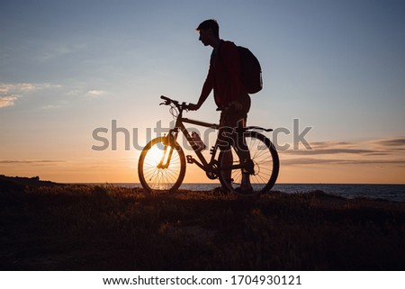 Silhouette of cyclist in motion at beautiful sunset. The idea and concept of a healthy lifestyle, exercise for health and quarantine exemptions