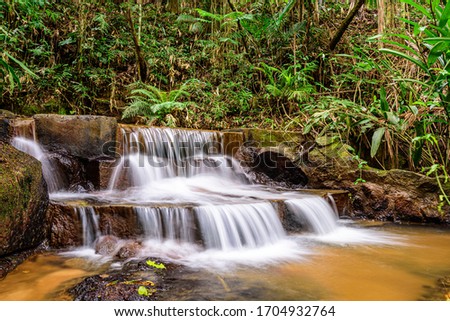 closeup of waterfall with long exposure effect, surrounded by rainforest