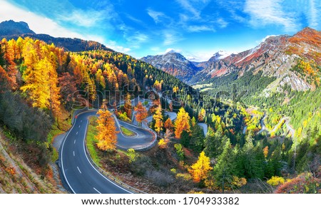 Stunning view of Maloja pass road at autumn time. Colorful autumn scene of Swiss Alps. Location: Maloya pass, Engadine region, Grisons canton, Switzerland, Europe.