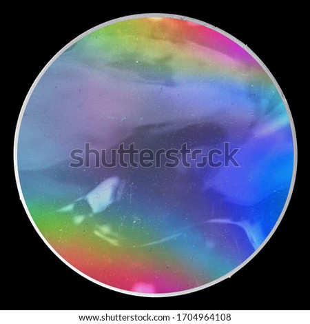 shiny and glossy looking foil sticker with neon rainbow texture on paper sheet isolated on black background. real high res macro photo.