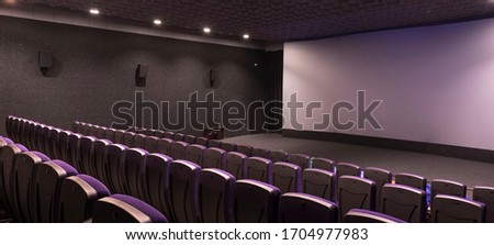 General plan of pink red empty unoccupied seats in the cinema hall. Watching a new movie panoramic photo