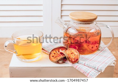 Bael fruit juice or quince tea and dried bael sliced fruit on rustic background. Thai or Asian healthy drink. Bael is helping the body to resist catching a cold. Selective focus