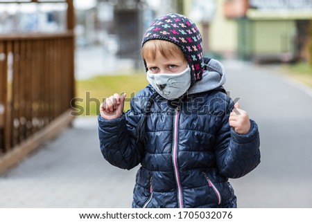 portrait of a little boy in a hat and blue hen, with a bandage on his face, two painted mustache seals are located on the streets showing different hand gestures, pandemic, virus