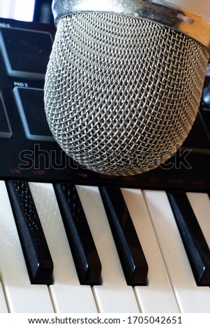 Vertical shot of musical studio with professional microphone and synth keyboard