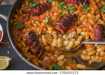 White beans with sausage on carrot oven, dried tomatoes and dried peppers