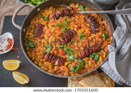 White beans with sausage on carrot oven, dried tomatoes and dried peppers