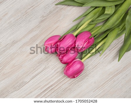Bouquet of pink tulips on wooden background. The holiday gift. The view from the top.