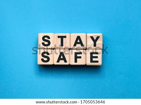 STAY SAFE - text on wooden cubes on a blue background Royalty-Free Stock Photo #1705053646