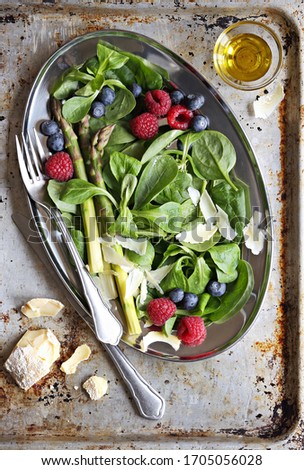 Salad with green asparagus, fresh berries and goat cheese. Selective focus