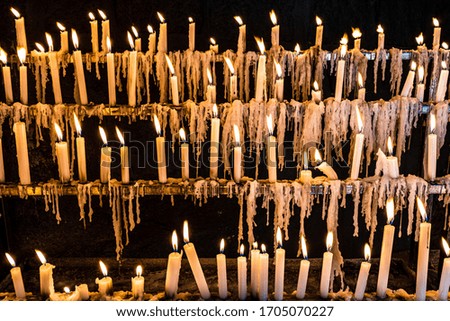 many candles burning in a sanctuary's wake